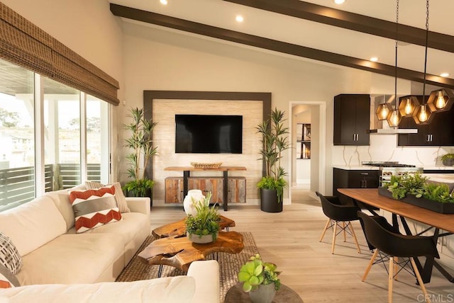 living room with vaulted ceiling with beams, a fireplace, and light wood-type flooring