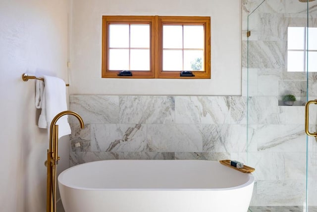 bathroom featuring tile walls and plus walk in shower