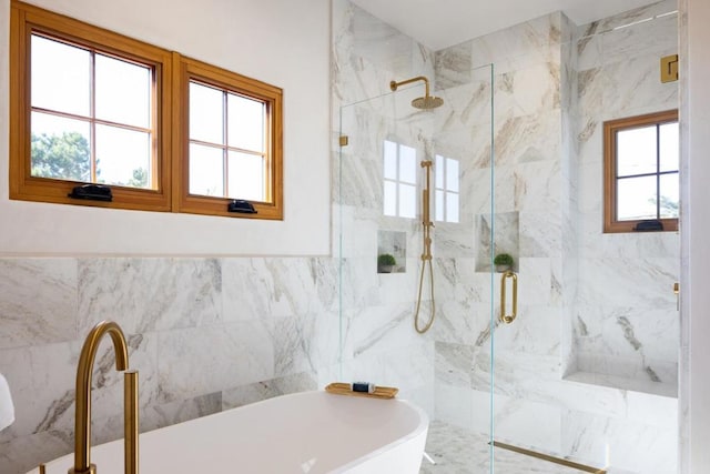 bathroom featuring a wealth of natural light, plus walk in shower, and tile walls