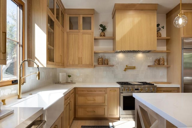 kitchen with light brown cabinets, sink, tasteful backsplash, pendant lighting, and high quality appliances