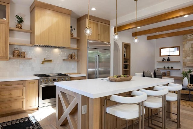 kitchen featuring pendant lighting, beamed ceiling, light hardwood / wood-style floors, and premium appliances