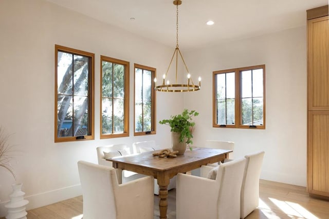 unfurnished dining area featuring a notable chandelier and light wood-type flooring