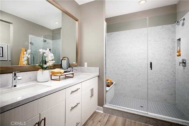 bathroom with vanity, hardwood / wood-style flooring, and a shower with door