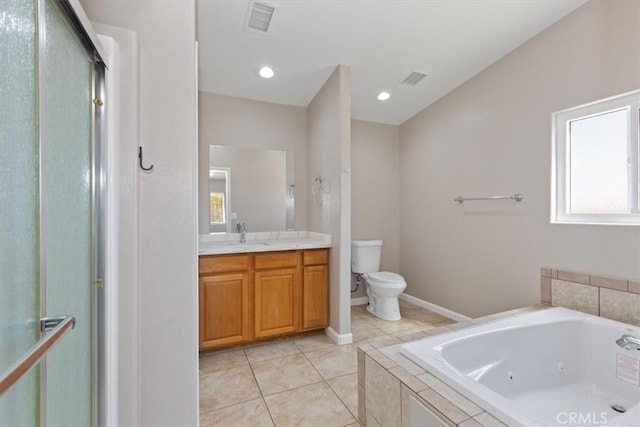 bathroom with toilet, vanity, tiled bath, and tile patterned floors