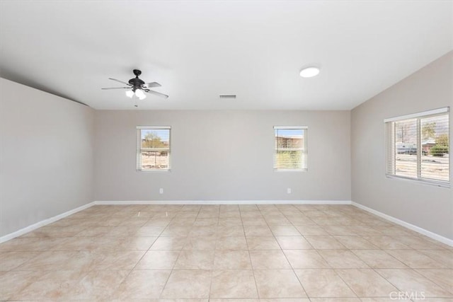 tiled empty room with vaulted ceiling, ceiling fan, and a healthy amount of sunlight