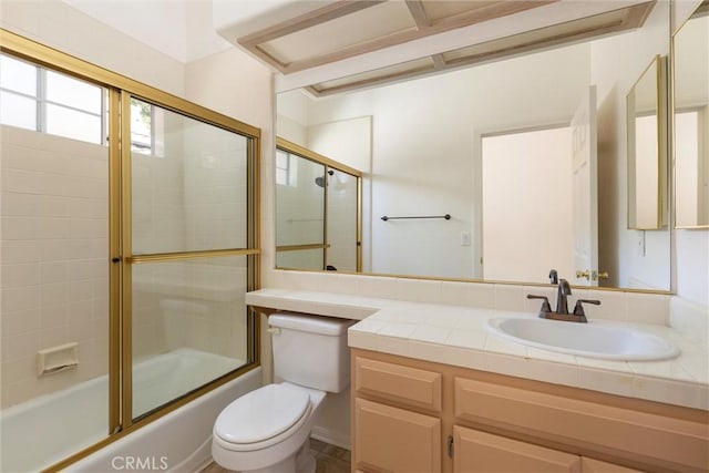 full bathroom with vanity, bath / shower combo with glass door, and toilet