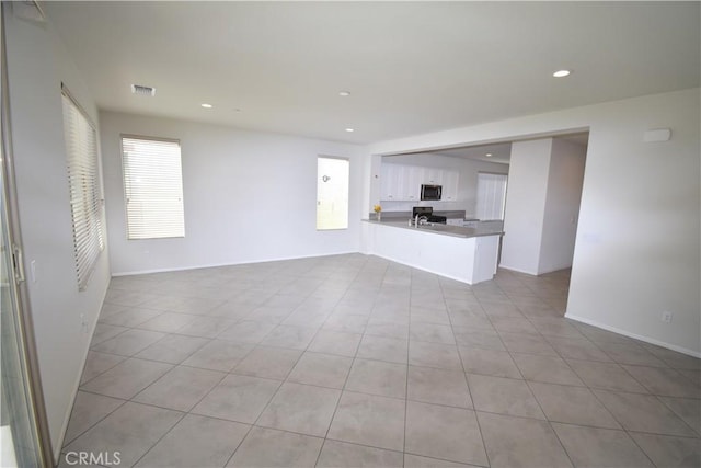 unfurnished living room with a wealth of natural light and light tile patterned floors