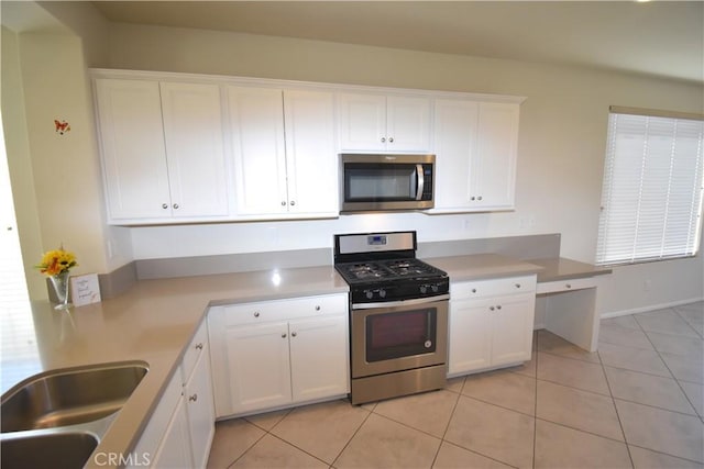 kitchen with white cabinets, stainless steel appliances, light tile patterned flooring, and sink