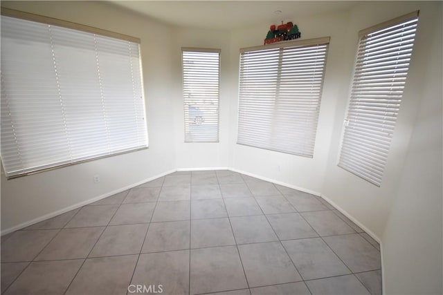 unfurnished room with plenty of natural light and light tile patterned floors