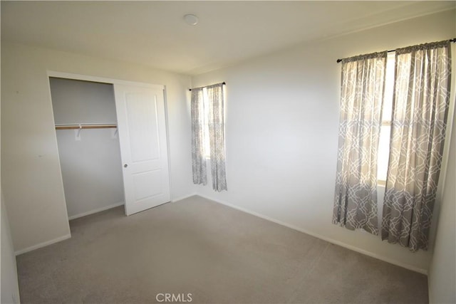 unfurnished bedroom with multiple windows, a closet, and carpet