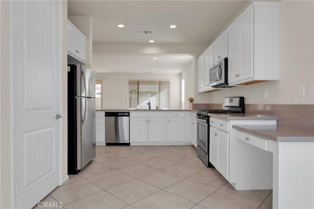 kitchen with visible vents, light tile patterned floors, recessed lighting, stainless steel appliances, and white cabinetry