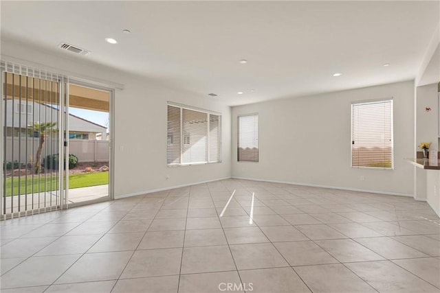 unfurnished room featuring visible vents, plenty of natural light, and light tile patterned flooring