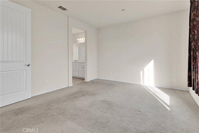 unfurnished bedroom featuring baseboards, visible vents, and light carpet