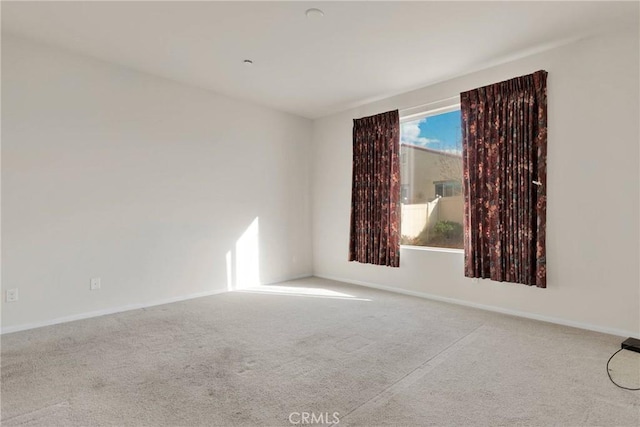 spare room featuring baseboards and carpet floors