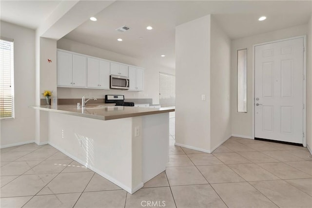 kitchen with a sink, plenty of natural light, appliances with stainless steel finishes, and white cabinets