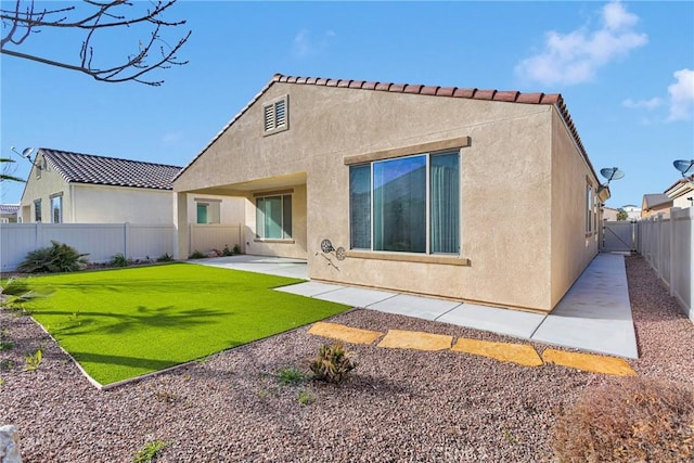 back of property featuring a patio area, a yard, a fenced backyard, and stucco siding