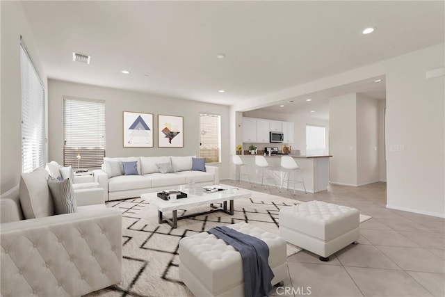 living room featuring light tile patterned flooring, recessed lighting, visible vents, and baseboards