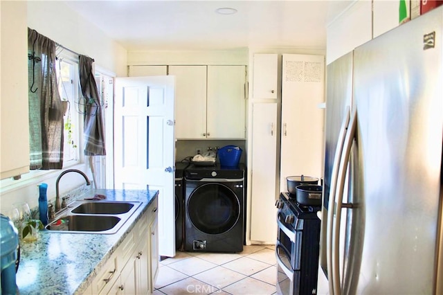 kitchen with sink, stainless steel fridge, light tile patterned flooring, light stone counters, and range