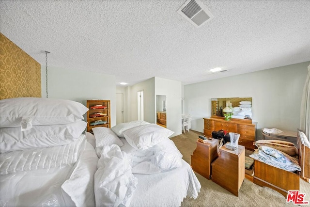 bedroom with a textured ceiling and light colored carpet