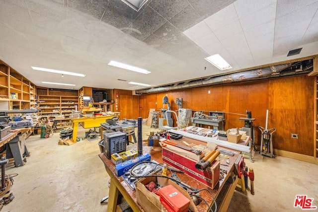 garage with a workshop area and wood walls