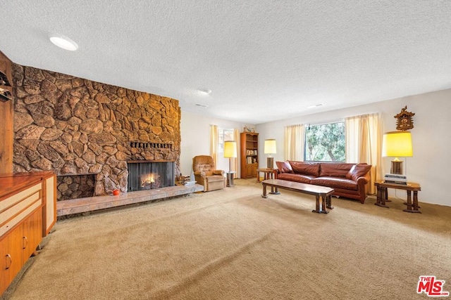 carpeted living room featuring a stone fireplace and a textured ceiling