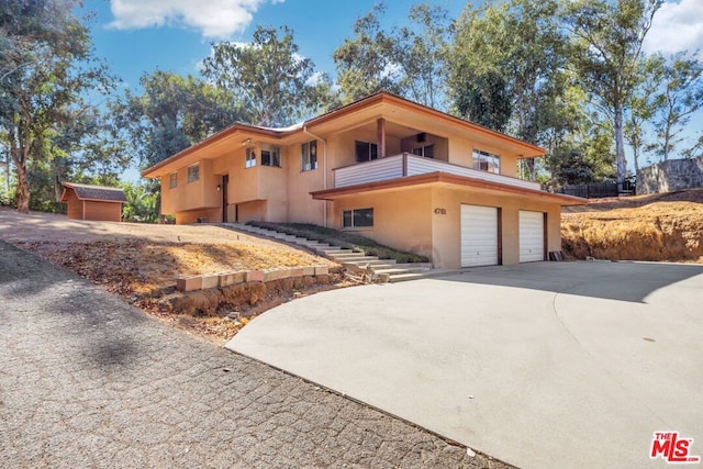 view of front of property featuring a garage and a balcony