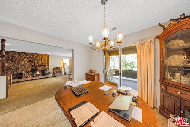 dining area featuring light carpet, a notable chandelier, a textured ceiling, and a fireplace