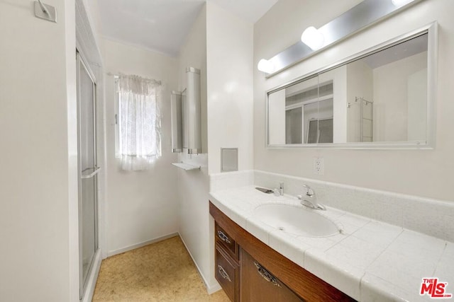 bathroom with vanity and a shower with door