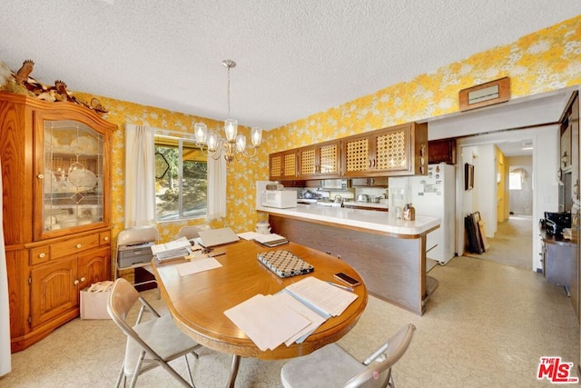 dining space with a textured ceiling and an inviting chandelier