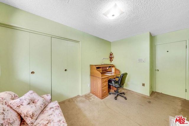 carpeted office featuring a textured ceiling