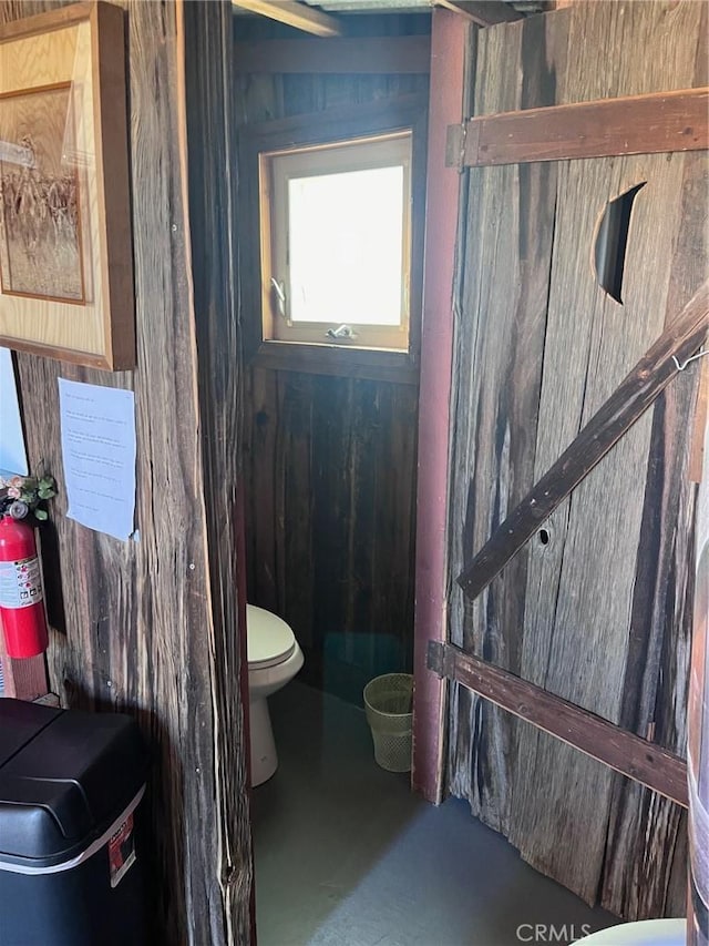 bathroom featuring concrete flooring and toilet