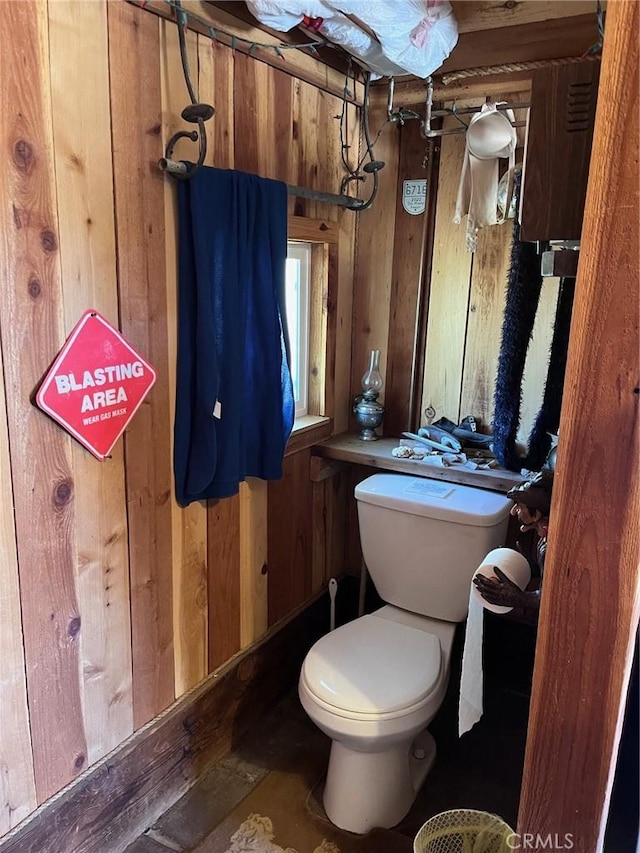 bathroom with toilet and wooden walls