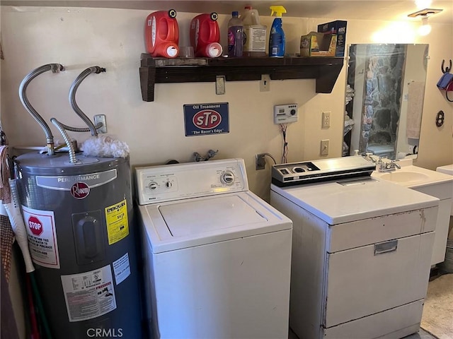 laundry room with water heater and washer and dryer