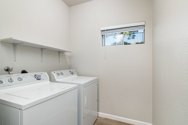 laundry room with washing machine and dryer and wood-type flooring