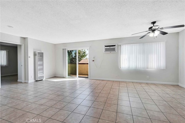 unfurnished room featuring a textured ceiling, light tile patterned flooring, and a wall unit AC