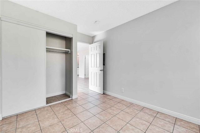 unfurnished bedroom featuring a closet and light tile patterned floors