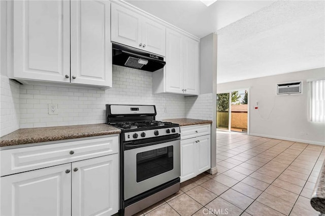 kitchen with stainless steel gas range oven, white cabinetry, decorative backsplash, and light tile patterned flooring