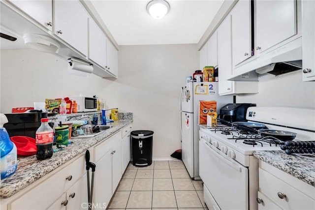 kitchen featuring white cabinets, light stone countertops, light tile patterned flooring, and white appliances