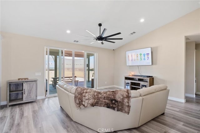 living room featuring light hardwood / wood-style flooring, ceiling fan, and lofted ceiling