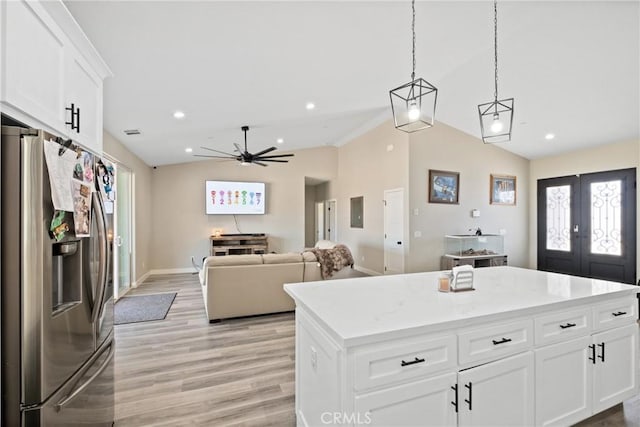 kitchen featuring a center island, light hardwood / wood-style flooring, stainless steel fridge with ice dispenser, vaulted ceiling, and white cabinetry