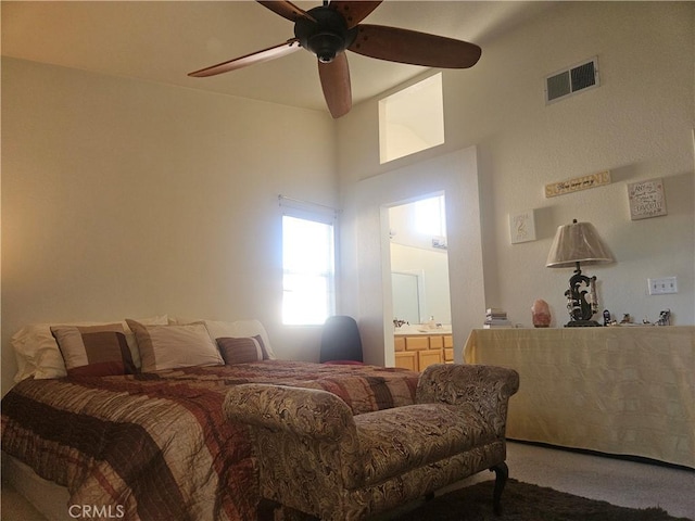 bedroom with carpet, ceiling fan, a towering ceiling, and ensuite bath