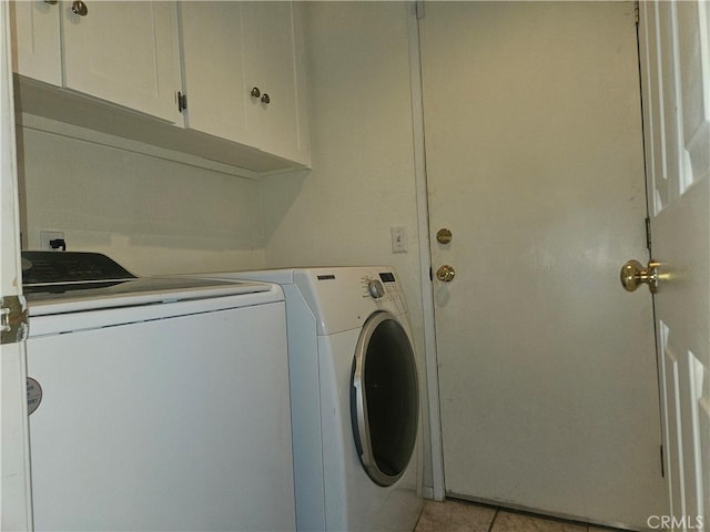 washroom featuring cabinets, light tile patterned floors, and washing machine and dryer