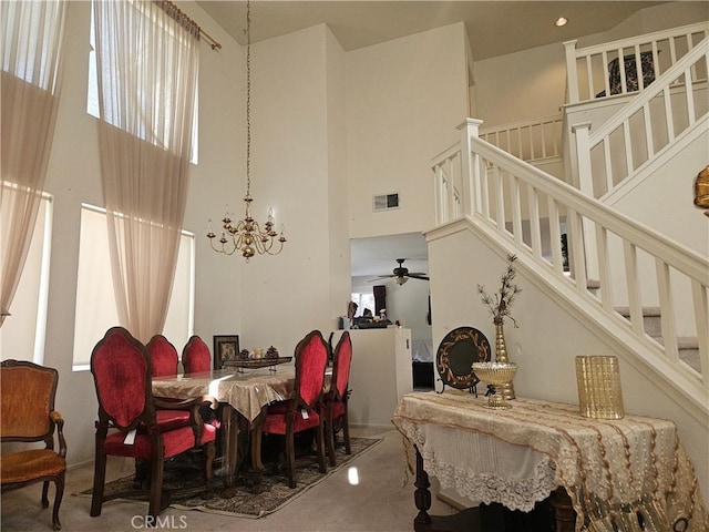 dining room featuring ceiling fan with notable chandelier and carpet floors