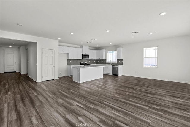 kitchen featuring dark hardwood / wood-style flooring, appliances with stainless steel finishes, and a center island