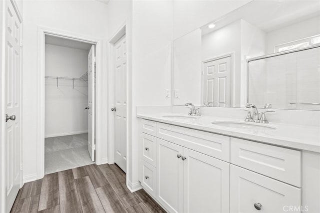 bathroom with vanity, wood-type flooring, and a shower with shower door