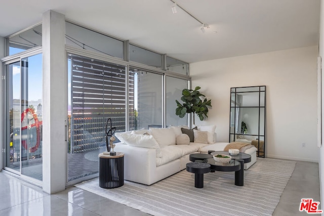 living room featuring expansive windows, concrete flooring, and rail lighting