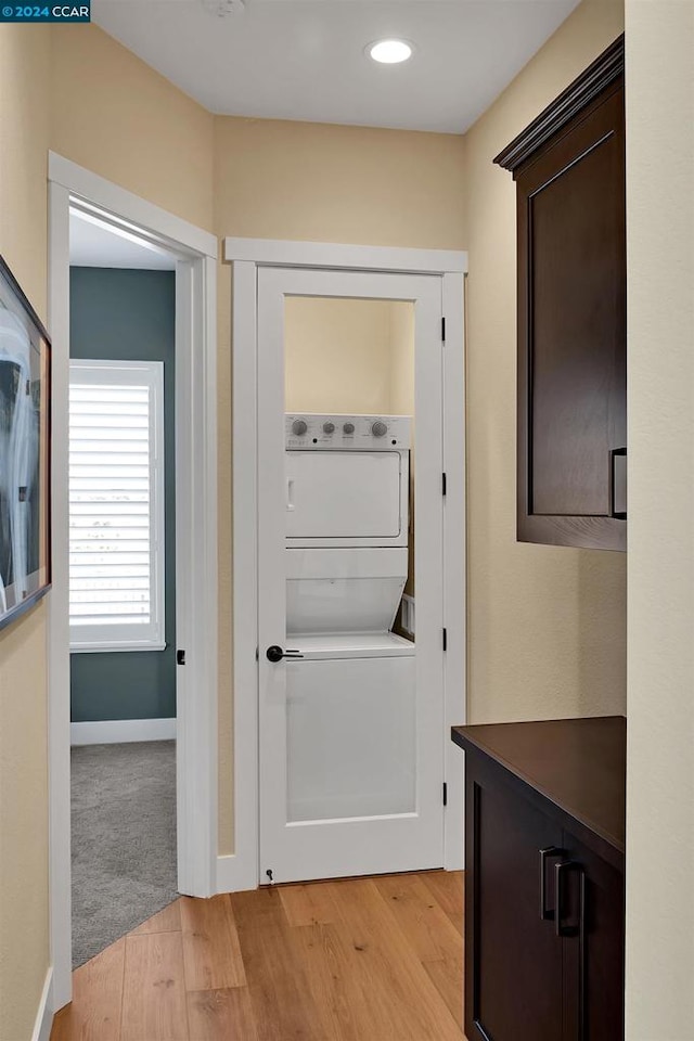 hallway featuring light wood-type flooring and stacked washer and clothes dryer