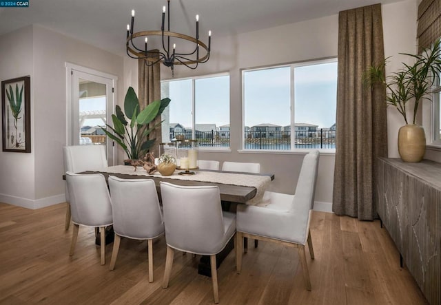 dining room with a healthy amount of sunlight, a water view, and light wood-type flooring