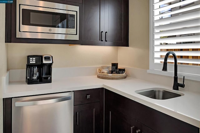 kitchen featuring stainless steel appliances, dark brown cabinets, and sink