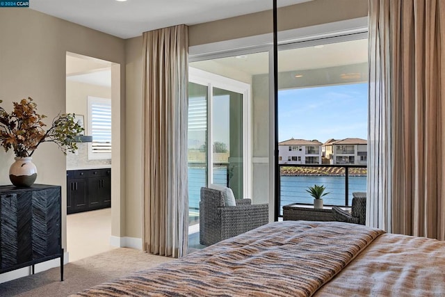 carpeted bedroom with a water view and access to outside